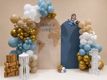 Travel-themed first birthday backdrop with blue, white and gold balloons
